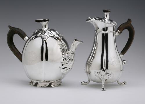Una tetera de plata antigua y jarra de leche