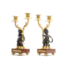 Napoleon III period candlesticks on a red marble decorated base featuring young kids carrying the candles