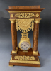 A French mahogany ormolu mounted portico mantel clock with oscillating movement, Empire ca. 1820-30.