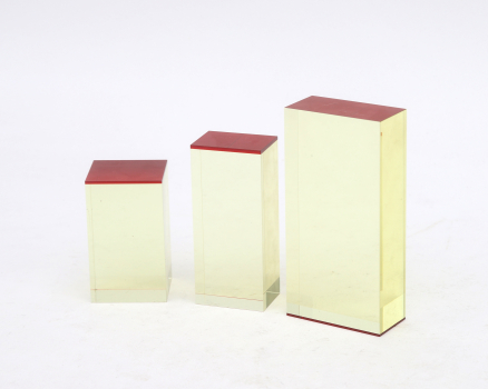 Drie optisch geslepen objecten bestaande uit geelglazen blokken met een rood vlak. Ongesigneerd. Met enkele krassen.  Herkomst: Galerie Rob van den Doel, Den Haag 1992.