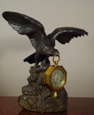 Een bronzen adelaar horlogestandaard met koetshorloge met kwartierrepetitie
