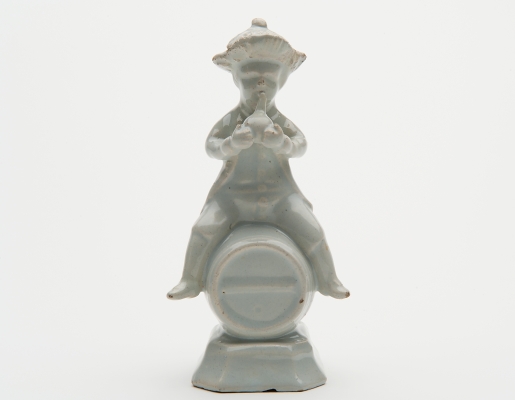 A White Figure of a Fellow Seated on a Barrel in Dutch Delftware