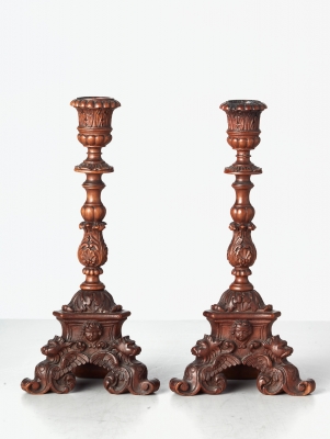 A small pair of Italian highly carved walnut single candlesticks, circa 1850