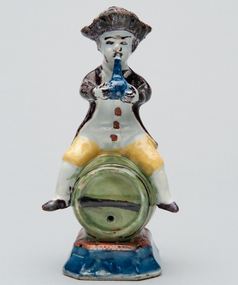 A Polychrome Figure of a Fellow Seated on a Barrel in Dutch Delftware