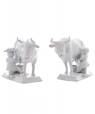 A Pair of White Cows with Milkers in Dutch Delftware